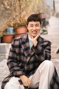 Portrait of young man sitting outdoors