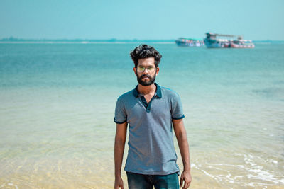 Portrait of young man standing at beach