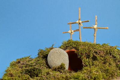 Low angle view of cross on field against clear sky