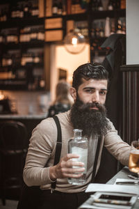 Young man drinking glass on table at restaurant