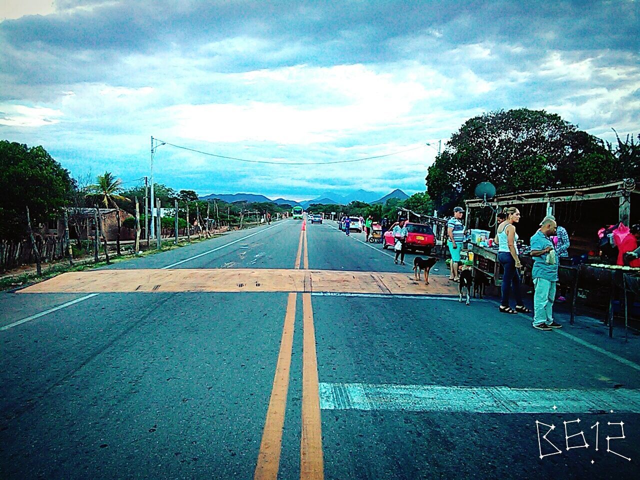 sky, the way forward, cloud - sky, diminishing perspective, vanishing point, cloudy, tree, road, cloud, outdoors, day, empty, nature, tranquility, grass, blue, no people, weather, tranquil scene, travel destinations, overcast, growth, scenics, beauty in nature, multi colored