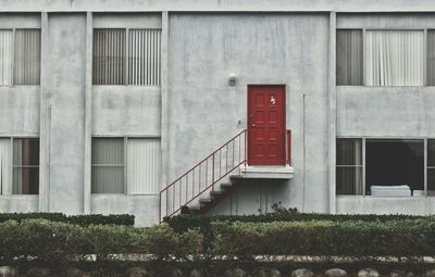 Apartment building with closed red door on wall