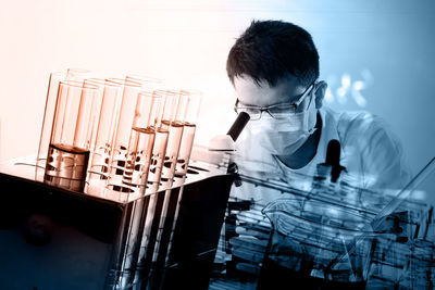 Close-up of doctor looking in microscope in laboratory