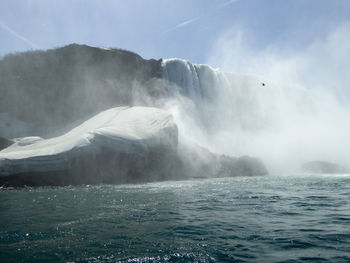 Scenic view of waterfall against sky
