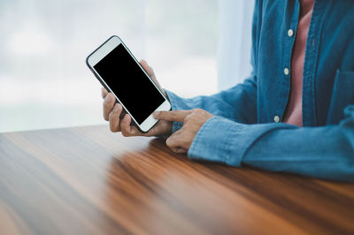 Midsection of man using mobile phone