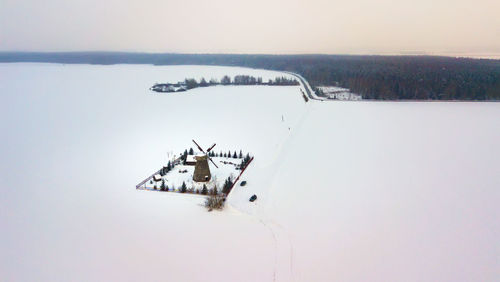 Traditional windmill on snow covered winter rural landscape 