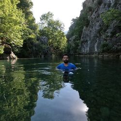 Portrait of man in river against trees