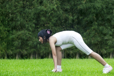Woman doing yoga on field