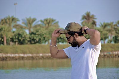 Man wearing sunglasses standing by beach 