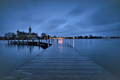 Pier over lake against sky at dusk