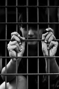 Close-up of human hand in cage