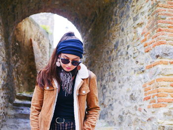 Young woman standing at old ruin