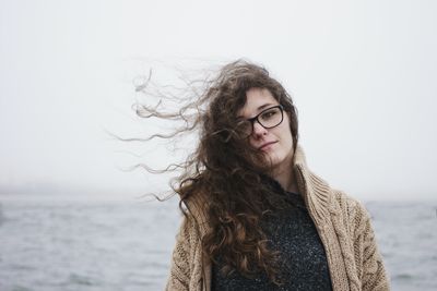 Portrait of beautiful young woman by sea