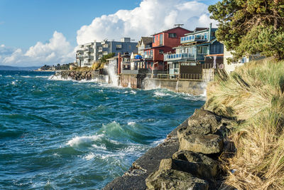 Waves on a windy day hit the shoreline near waterfront homes in west seattel, washington.