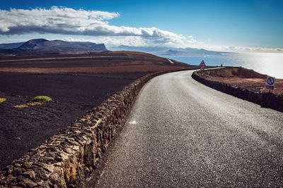 Road by field at canary islands against sky