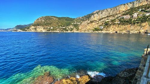 Scenic view of bay against clear blue sky