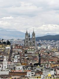 View of cityscape against cloudy sky