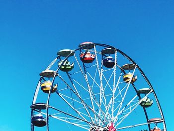 Low angle view of ferris wheel against clear blue sky