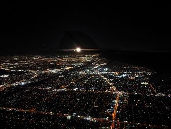 Aerial view of illuminated cityscape against sky at night