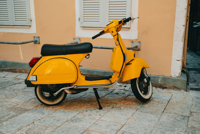 Motor scooter parked on street against building