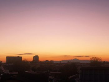 High angle view of silhouette buildings against sky during sunset