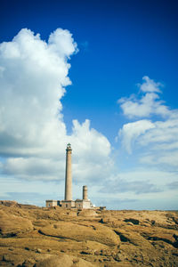 Low angle view of lighthouse on field against sky