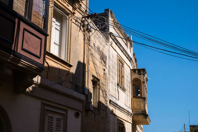 Low angle view of buildings against clear blue sky