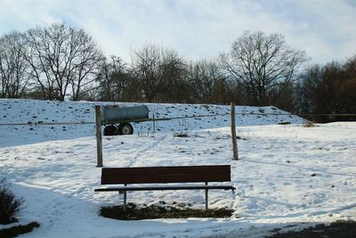 Lifeguard hut on snow covered landscape against sky