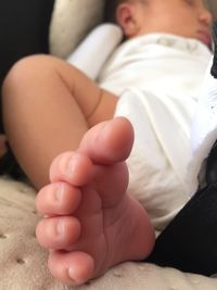 Midsection of baby boy lying on bed