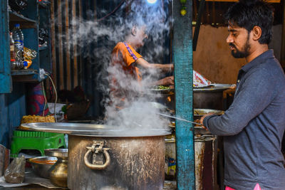 Side view of man preparing food at market