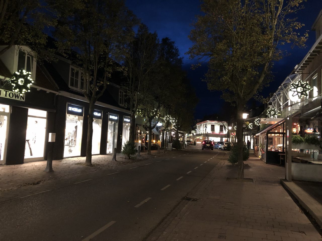 ILLUMINATED STREET BY BUILDINGS AT NIGHT