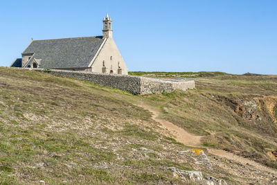 Old building on field against clear sky