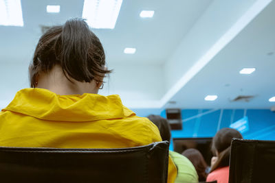 Rear view of woman with yellow umbrella