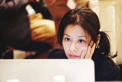 Serious woman looking at laptop in office