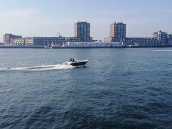 Scenic view of sea against buildings in city