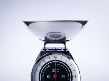 Close-up of old-fashioned weighing scale against blue background