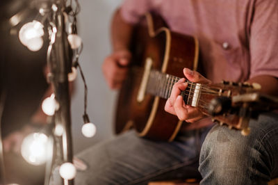 Midsection of man playing guitar