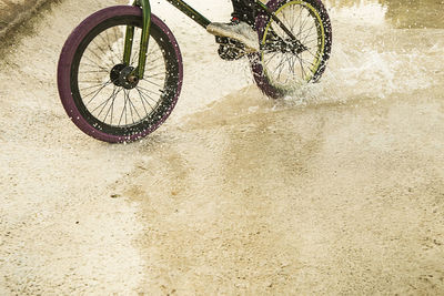 Bicycle parked on wet land