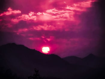 Low angle view of silhouette mountain against romantic sky