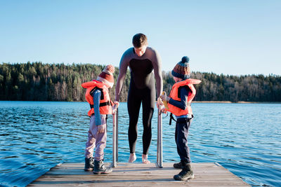 Father and his children cold water swimming at the beach in sweden