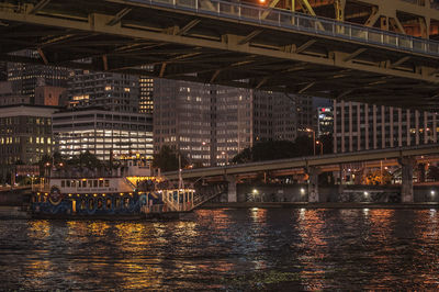 Bridge over river in city at night