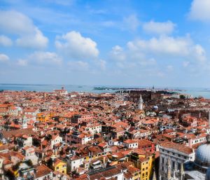 High angle view of townscape by sea against sky