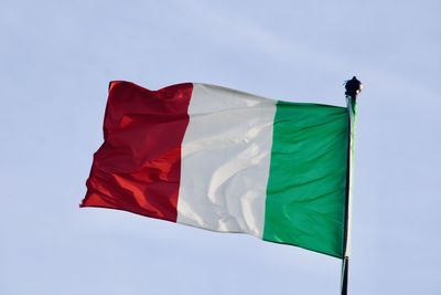 Low angle view of flag against blue sky