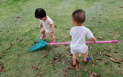 Full length of siblings playing on grass