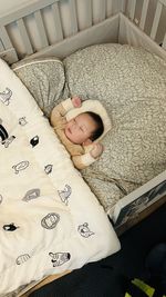 High angle view of baby boy sleeping on bed at home