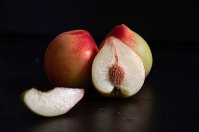 Close-up of apple on table against black background