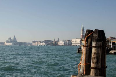 View of buildings by sea against clear sky