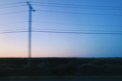 Electricity pylon against sky during sunset