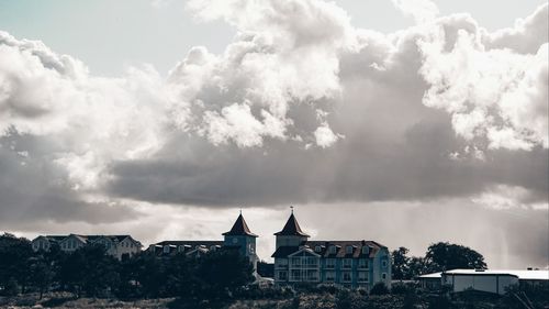View of buildings in town against cloudy sky