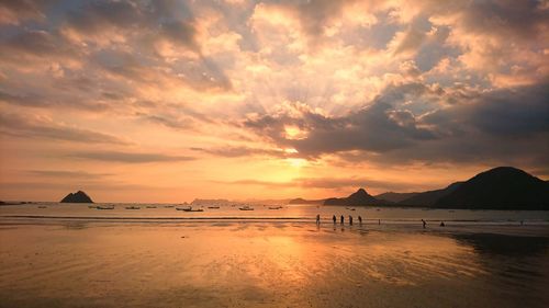 Scenic view of sea against dramatic sky during sunset